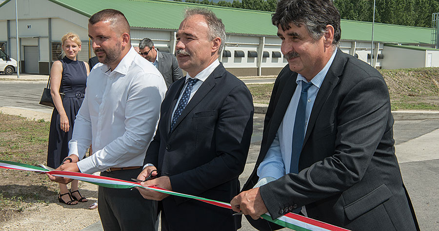 Trois hommes coupent un ruban.